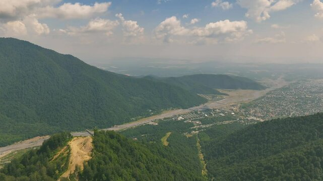 Drone view of lush green mountains with forest and unpaved roads on hill in Gebele, Azerbaijan