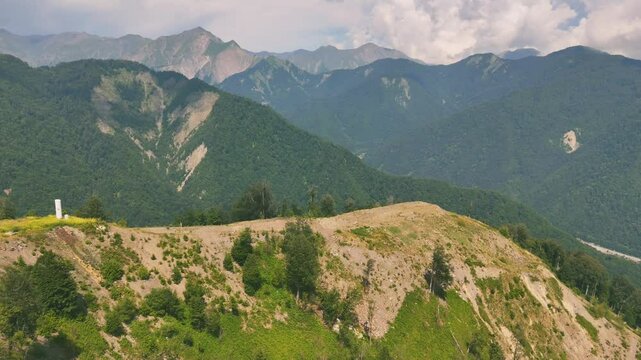 Drone view of lush green mountains with forest and unpaved roads on hill in Gebele, Azerbaijan