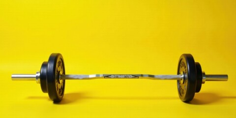 A Close-Up View of a Loaded Barbell Resting on a Vibrant Yellow Surface