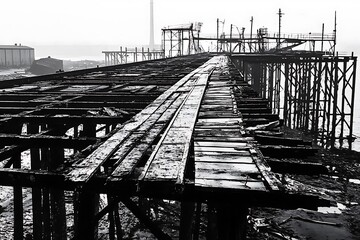 Naklejka premium An abandoned pier stands as a testament to time and decay.