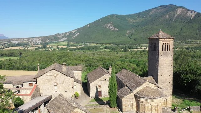 Aerial view of bell tower and apse of the Mozarab Pre-Romanesque or Romanesque Church of San Pedro de Larrede in the Serrablo Region. Aragon. Spain. High quality 4k footage