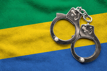 Flag of Gabon and police handcuffs. Crime and offenses in country Concept
