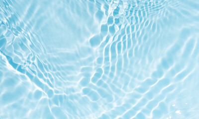 Bluewater waves on the surface ripples blurred. Defocus blurred transparent blue colored clear calm water surface texture with splash and bubbles. Water waves with shining pattern texture background.
