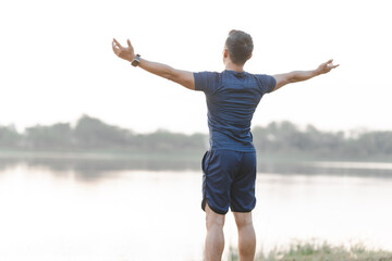 A male athlete enjoys a morning run in the park, smiling and exercising outdoors. Embracing fitness...