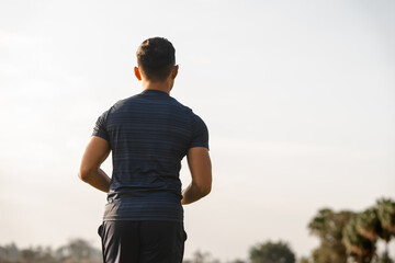 A male athlete enjoys a morning run in the park, smiling and exercising outdoors. Embracing fitness...