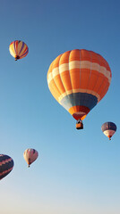 Fototapeta premium A group of hot air balloons rising into a clear blue sky.