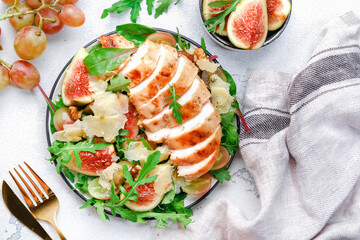 Delicious lunch with chicken, figs, cheese, grape and herbs. White background, top view