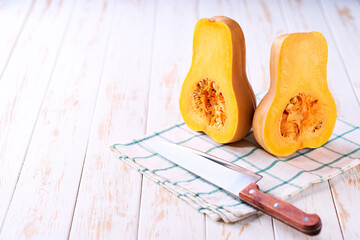 two halves of butternut squash  on a light wooden table, selective focus.