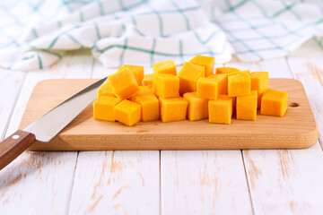 Cubed butternut squash on wooden cutting board copy space for text.