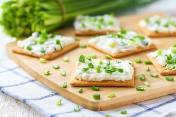 Cheese dip with savory biscuit and and spring onions on a kitchen table, selective focus.