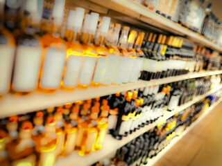 aisle of abstract blurred glass liquor bottles. shelved alcohol spirits wine at a market. drink beverage shopping setting illustration defocused backdrop
