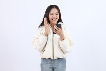 Fototapeta premium Woman Expresses Joy and Excitement While Using Smartphone, Celebrating Good News Enthusiastically.