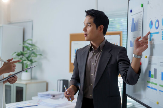 Asian businessman presenting financial data analysis during a meeting