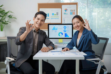 Asian businesspeople showing ok sign while working together in office
