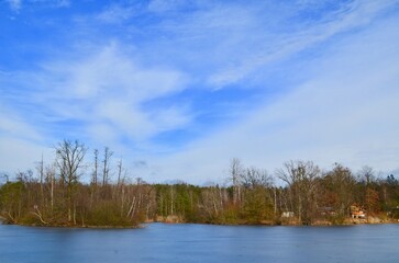 lake landscape, autumn frozen pond, blue sky background