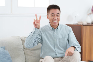 ピースサインをする笑顔の高齢者男性