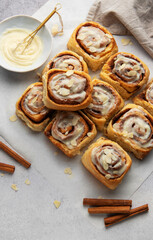 Freshly baked cinnamon rolls topped with icing and almond slivers