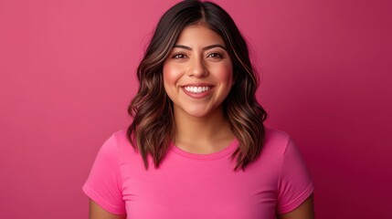 Fototapeta premium a happy Hispanic woman wearing a pink t-shirt, against a solid color background.