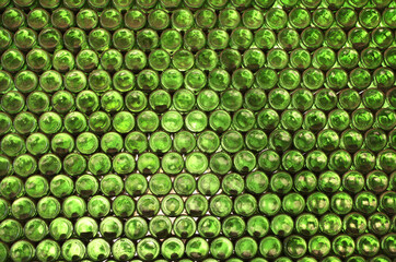 Full frame wall with empty green beer bottles bottoms. Alcohol theme. Endless rows of wine bottles....