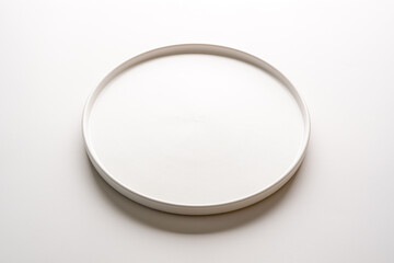 Top view of empty ceramic white plate on white background