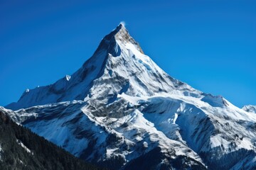 A breathtaking view of a snow capped mountain peak against a clear blue sky, showcasing nature's beauty during a bright sunny day in the highlands