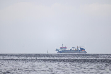 
a bay with calm water and a ship visible in the distance.