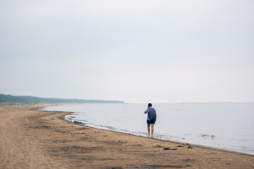 
A woman walks along the sea beach