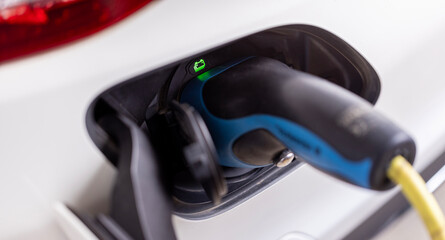 charging for electric car, power cable pump plug in charging power to electric vehicle EV car. ...