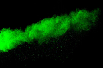 Green color powder explosion cloud on black background.Green dust splash.