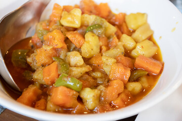 Colorful vegetable stew in a bowl. Aloo Matar is a delicious North Pakistan curry made with...