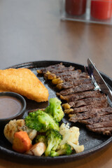 Delicious steak with hash brown, vegetables and sauce.