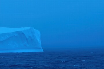 Iceberg Gradient: An iceberg in the ocean with colors transitioning from icy blue to deep ocean blue
