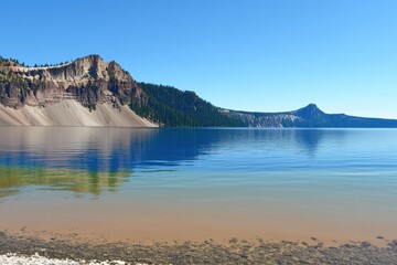 Obraz premium Mountain Lake Gradient: A mountain lake with water transitioning from clear near the shore to deep blue in the center.