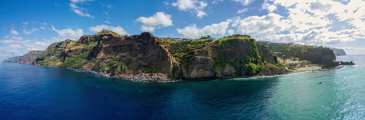 Aerial view of the Madeira island from the ocean, large panoramic image of the island, coast, cliff and waterfall