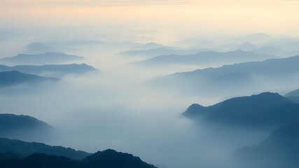 Fototapeta premium Serene panorama of misty mountains at sunrise, layers of blue hues in a tranquil landscape, peaceful nature scene,