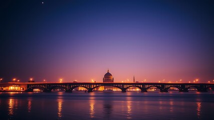 Illuminated bridge spanning a river at dusk with a majestic dome building in the background, creating a stunning cityscape.