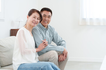 部屋にいる笑顔のシニア夫婦