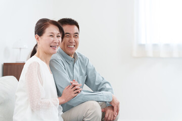 部屋にいる笑顔のシニア夫婦