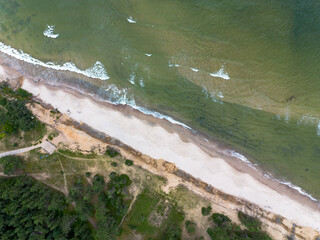 Coast of the Baltic Sea, waves rolling along the sandy shore, view from above.