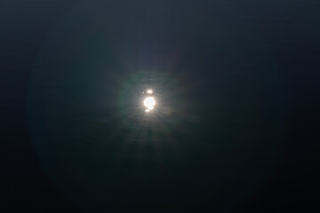 Sun reflection in black river water, background. Copy space.