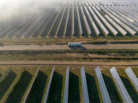A truck travels alongside an expansive solar energy site, highlighting the synergy between transportation and sustainable energy production in a developing area in Zaragoza Spain
