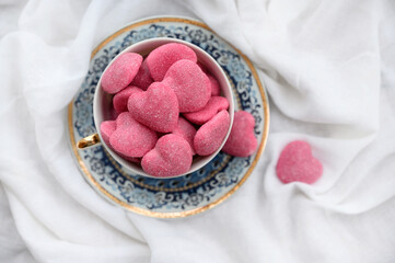 Pink heart-shaped candies in a cup. Valentine's Day background