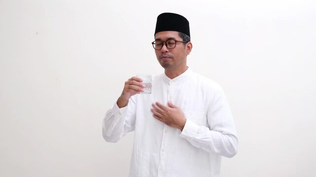 Muslim man drinking a glass of water when break fasting