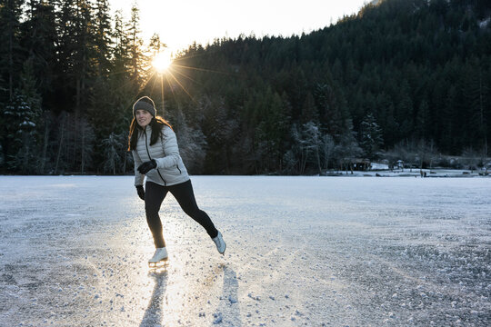 Winter scene of a skater enjoying the outdoors on a frozen lake.