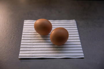 Two chicken eggs on the kitchen table on a napkin