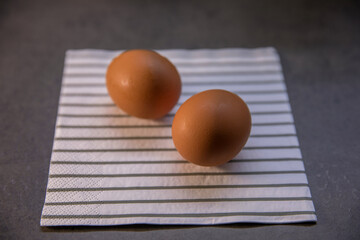 Two chicken eggs on the kitchen table on a napkin