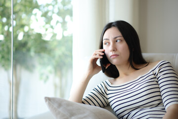 Bored asian woman waiting for attention talking on phone