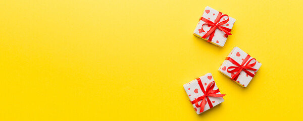 Valentine day composition: red gift box with bow and heart. Christmas present. View from above. Space for text. Holday greeting card