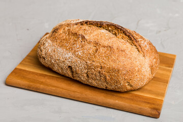 Freshly baked bread on cutting board against white wooden background. perspective view bread with copy space