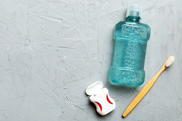 Mouthwash and other oral hygiene products on colored table top view with copy space. Flat lay....